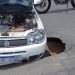 Carro cai em buraco após asfalto ceder no centro de Linhares
