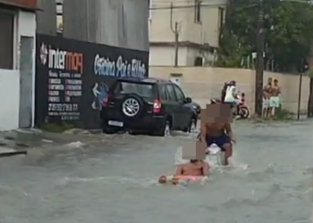 VÍDEOS – Jovens se divertem em rua alagada durante forte chuva em Linhares